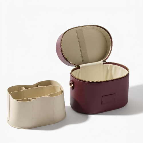 Brun Essential sminkebag sett fra siden med charm-ring og strap-løkke